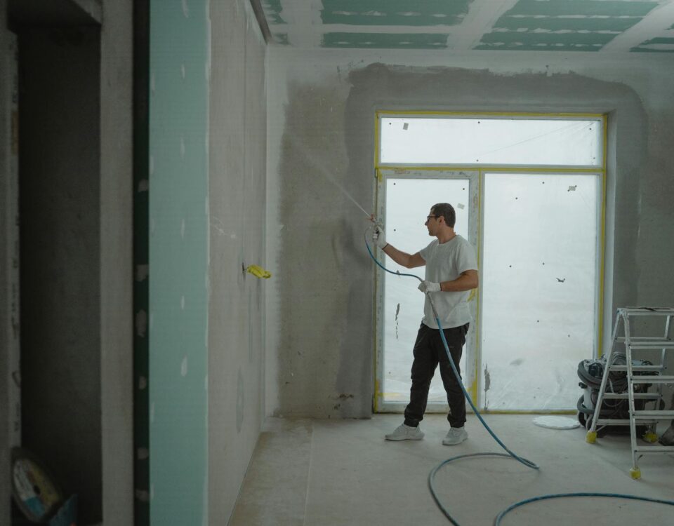 man in white dress shirt and black pants holding a spray hose